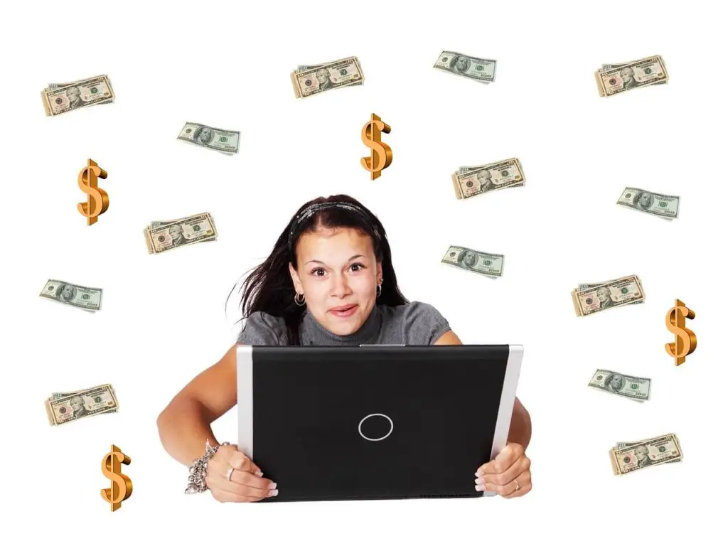 A woman holding a laptop with money flying around