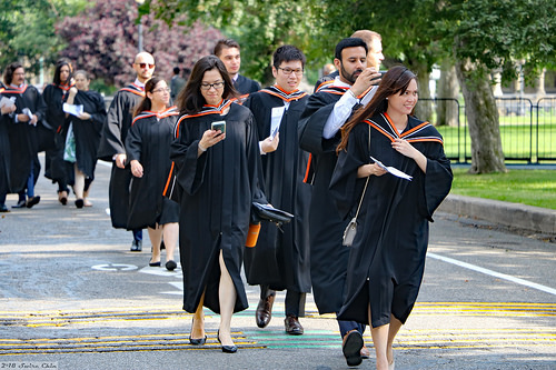 A group of fresh graduates walking happily on the street on a graduation day.