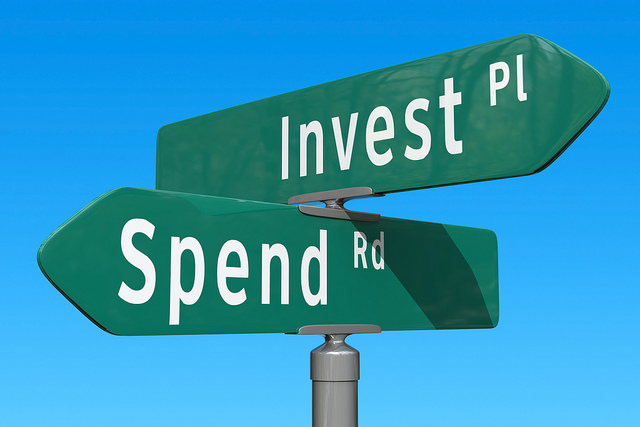Signboard with the word invest and spend.
