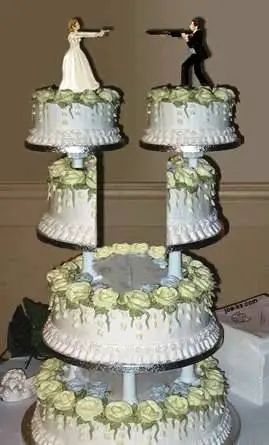 A divorced cake with the bride and bridegroom pointing guns at each other.
