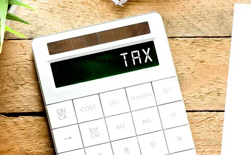A white calculator with the word TAX on the calculator screen.