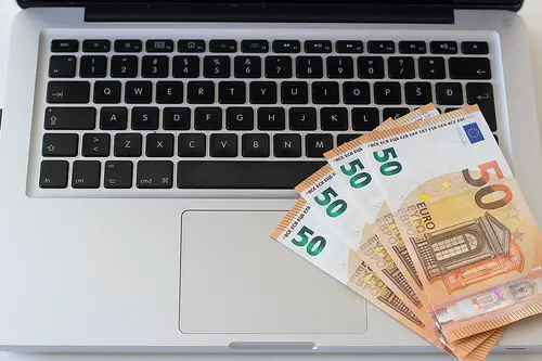 Cash notes on a laptop as an example of Google AdSense earnings.