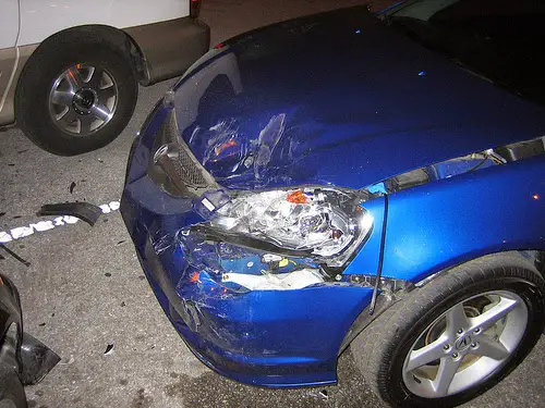 a blue car with dented bumper from hit and run