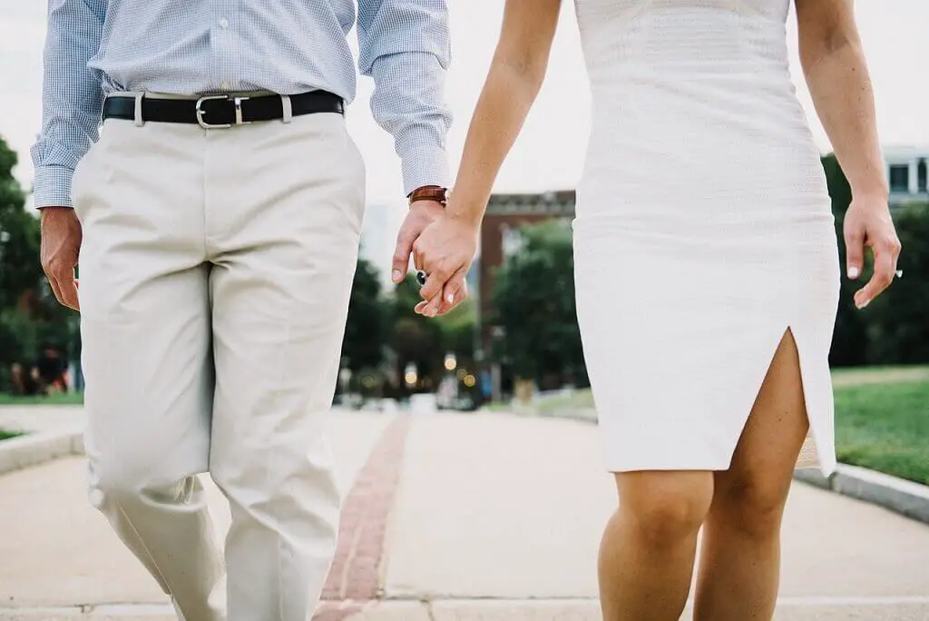 An adult couple holding hands representing a financially happy marriage.