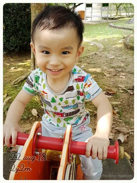A toddler happily riding a rocking horse as an example of toddler's third-year expenses.