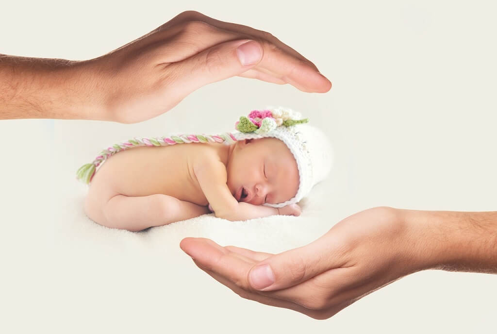 Hands protecting a newborn