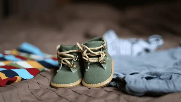 A pair of baby shoes and a few baby clothes.