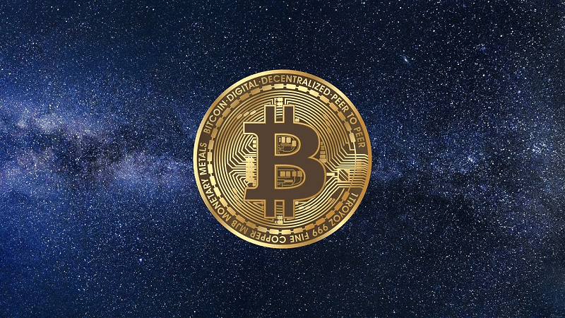gold plated bitcoin coin with cosmic background